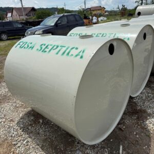 Rezervoare mari albe de fosa septică pe șantier.